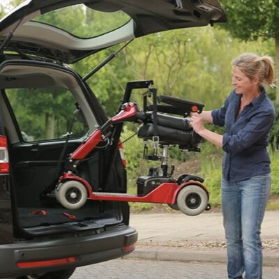 lady putting a mobility scooter into a boot of a car