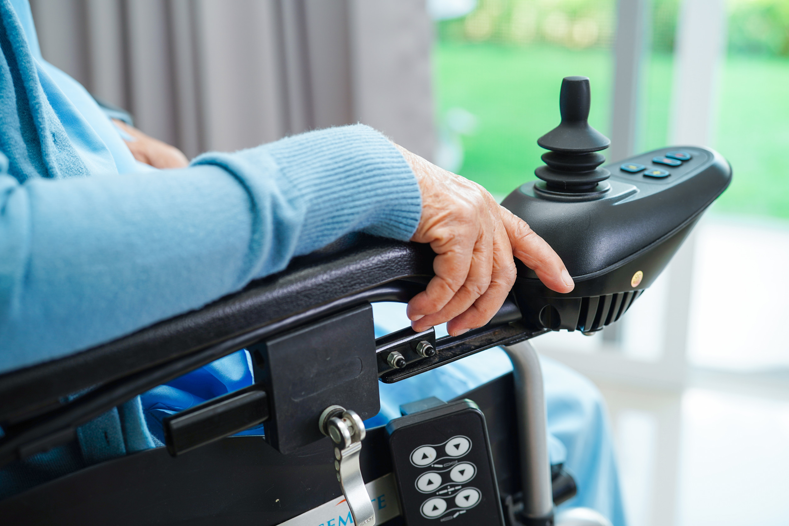 Asian elderly woman disability patient sitting on electric wheel