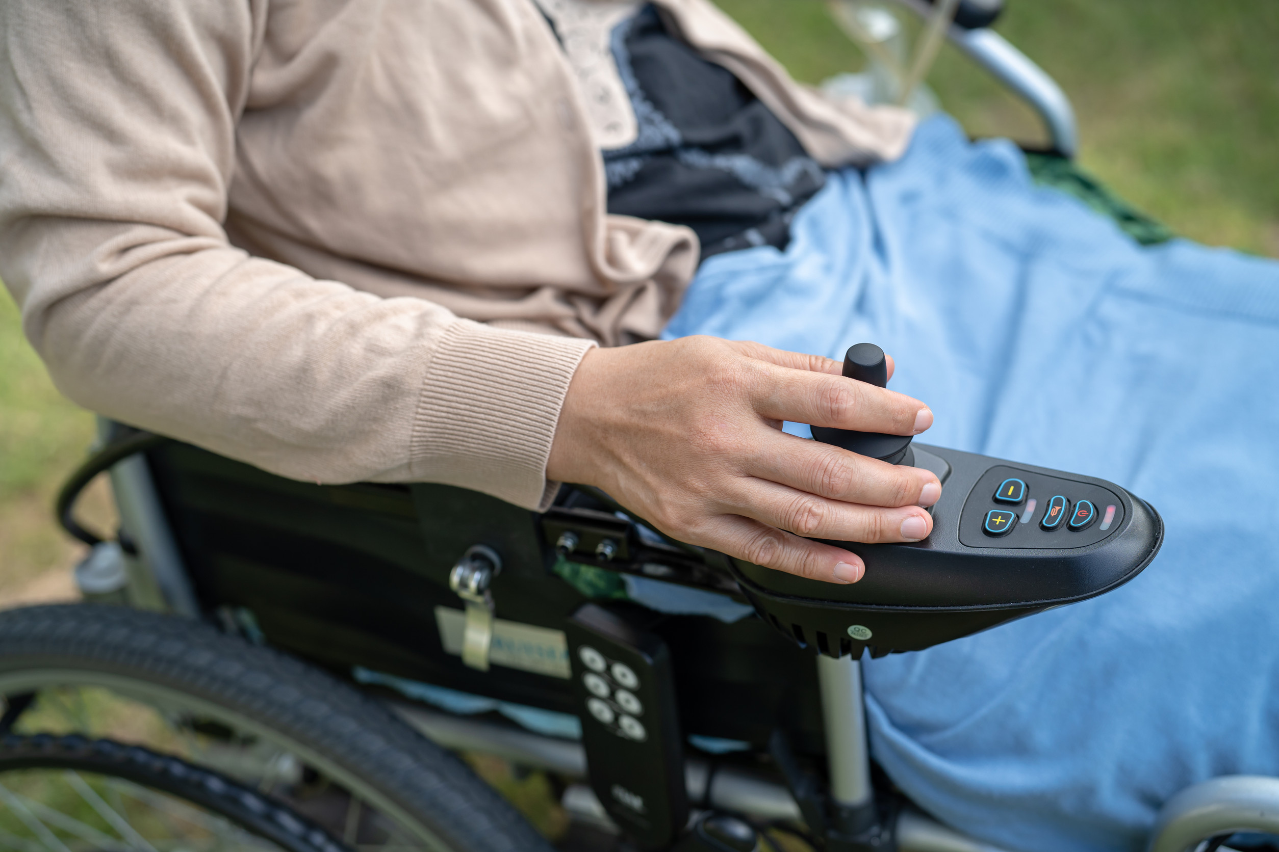 Asian lady woman patient on electric wheelchair with joystick an